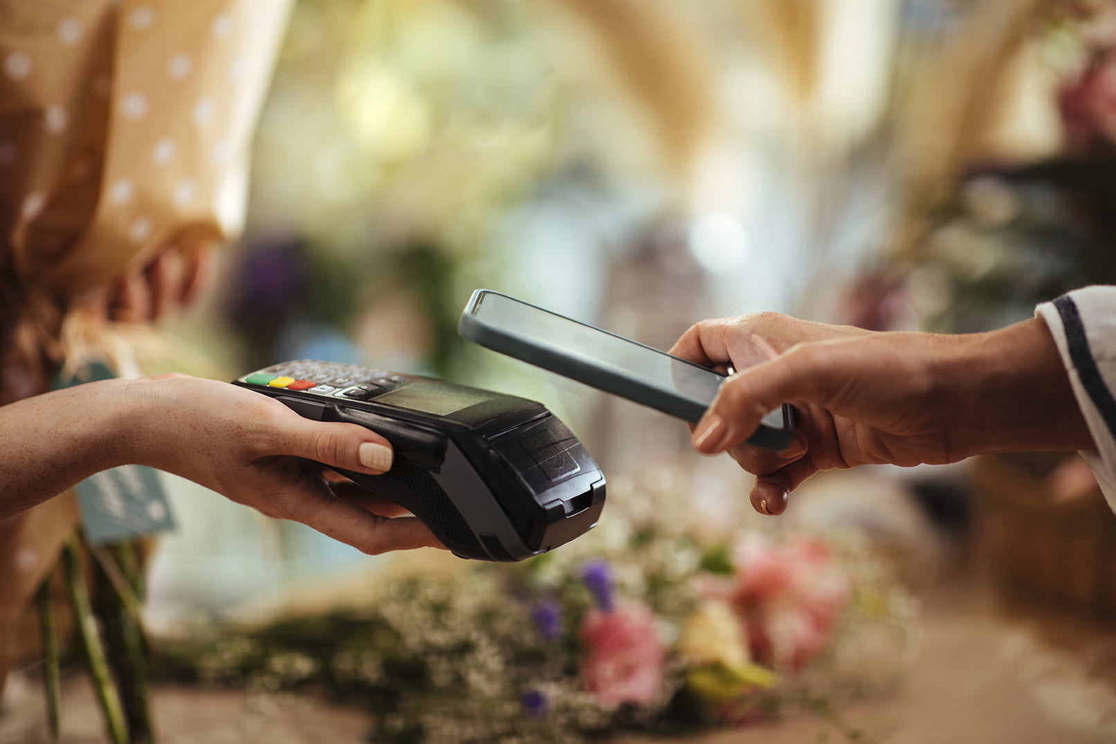 Person betaler kontaktløst med mobilen i butikk.